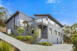 Casa gris con ventanas de cristal y entrada en Panoramic water views with stunning interiors en Bellerive