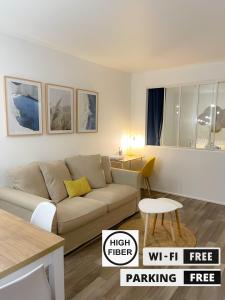 uma sala de estar com um sofá e uma mesa em HYGGE - Superbe Apt rénové Rouen Gare avec parking privatif em Rouen