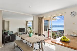 a living room with a table and a view of the ocean at Scenic Sandy Bay Home with Stylish Interior in Sandy Bay