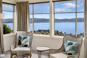 a living room with two chairs and a view of the water at Scenic Sandy Bay Home with Stylish Interior in Sandy Bay