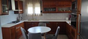 une cuisine avec des placards en bois et une table avec des chaises dans l'établissement Seaside Boutique Villa, à Vólos