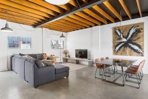 un salon avec un canapé et une table dans l'établissement Stunning Warehouse Pad - Moments from the Waterfront, à Hobart