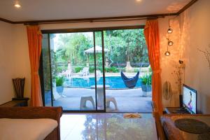 uma sala de estar com uma porta de vidro deslizante para uma piscina em Royal Cottage Residence em Lamai