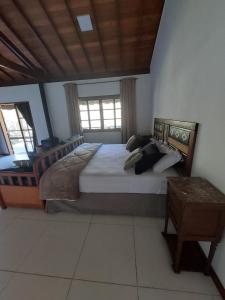 ノバ・フリブルゴにあるLumiar Eco Lodge - Chalé Pedra Riscadaのベッドルーム1室(大型ベッド1台付)