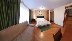 een woonkamer met een bed en een bank bij Hodu Hospedaje in Quito