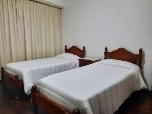 dos camas sentadas una al lado de la otra en una habitación en Hermoso Departamento centrico en Córdoba