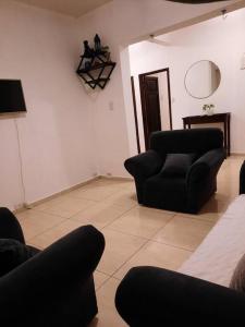 salon z 2 krzesłami i telewizorem w obiekcie Hermoso Departamento centrico w Córdobie