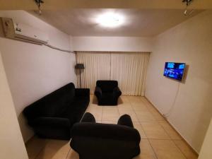 uma sala de estar com um sofá e duas cadeiras em Hermoso Departamento centrico em Córdoba