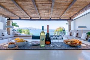 a table with two bottles of wine and wine glasses at House On The Sea Porto Rotondo in Porto Rotondo
