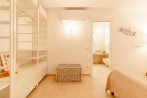 Un dormitorio blanco con una cama y un baño. en House On The Sea Porto Rotondo, en Porto Rotondo 30 fotos más