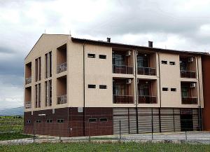 an apartment building with a fence in front of it at Incanto Family Hotel in Sevlievo