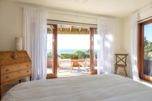 Schlafzimmer mit einem Bett und Meerblick in der Unterkunft The Villino at Cypress Ridge Estate in Onetangi