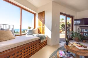 Pokój z fotelem przy oknie i widokiem na ocean w obiekcie The Villino at Cypress Ridge Estate w mieście Onetangi