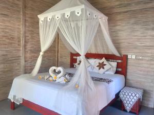 レンボンガン島にあるVista Huts Lembonganのベッドルーム1室(白いカーテン付きのベッド2台付)