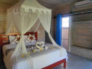 two stuffed animals sitting on a bed in a bedroom at Vista Huts Lembongan in Nusa Lembongan
