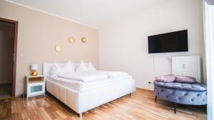 een slaapkamer met een wit bed en een televisie bij Alpe Adria Apartments - Top 11 by S4Y in Oberaichwald