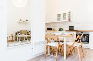 cocina con armarios blancos, mesa y sillas en N28 Deluxe Apartment, en Budapest