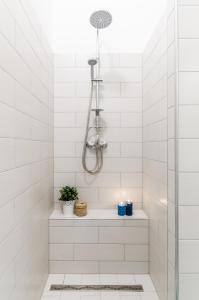 y baño con ducha de azulejos blancos. en N28 Deluxe Apartment, en Budapest