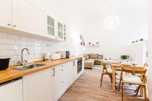 una cocina con armarios blancos y una mesa con sillas. en N28 Deluxe Apartment, en Budapest
