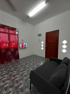 a room with a couch and a red door at Homestay Idaman B B with 2 room aircond 2 Quen Bed and Not Sharing Room -Privacy in Kuala Terengganu