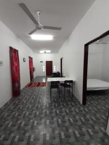 a room with chairs and a table and a ceiling fan at Homestay Idaman B B with 2 room aircond 2 Quen Bed and Not Sharing Room -Privacy in Kuala Terengganu
