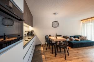 a kitchen and living room with a table and a couch at Deluxe Appartement Arve in Valdaora