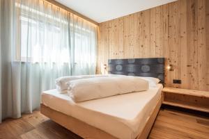 a bedroom with a large bed and a window at Deluxe Appartement Arve in Valdaora