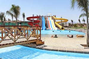 een zwembad met een waterpark met mensen erin bij Three Corners Sea Beach Resort in Baai van Coraya