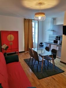 a living room with a red couch and a table at Centre Confolens studios rénovés in Confolens