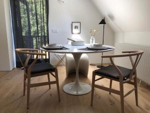 una mesa blanca con 2 sillas y una mesa blanca con platos y cuencos en Het Wagenhuis, en Loon op Zand