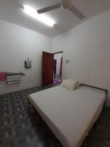 a large white bed in a room with a ceiling fan at Homestay Idaman B B with 2 room aircond 2 Quen Bed and Not Sharing Room -Privacy in Kuala Terengganu