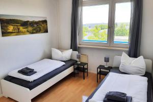 a bedroom with two beds and a window at Apartments Halle West in Nietleben