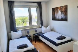 a small room with two beds and a window at Komfortable Monteurwohnungen Halle, Perfekt für Industriearbeiter Leuna, Flughafen, DHL in Nietleben