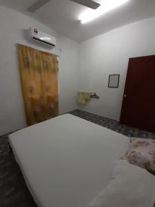 a bedroom with a white bed and a window at Homestay Idaman B B with 2 room aircond 2 Quen Bed and Not Sharing Room -Privacy in Kuala Terengganu