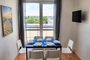a dining room with a table and chairs and a window at Apartments Halle West in Nietleben
