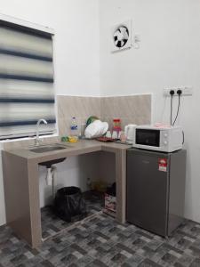 a kitchen with a counter with a microwave and a refrigerator at Homestay Idaman B B with 2 room aircond 2 Quen Bed and Not Sharing Room -Privacy in Kuala Terengganu