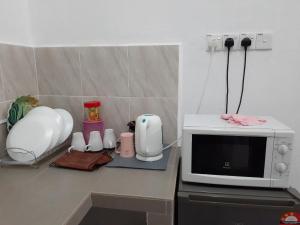 a kitchen counter with a microwave and appliances on it at Homestay Idaman B B with 2 room aircond 2 Quen Bed and Not Sharing Room -Privacy in Kuala Terengganu
