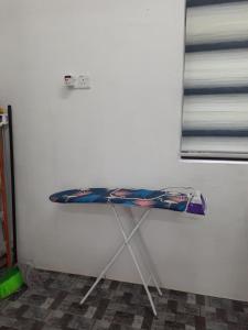 a table sitting against a white wall in a room at Homestay Idaman B B with 2 room aircond 2 Quen Bed and Not Sharing Room -Privacy in Kuala Terengganu