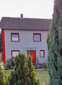 une maison rouge et blanche avec une porte rouge dans l'établissement Gästezimmer Salzgitter II in Wolfenbüttel, à Wolfenbüttel