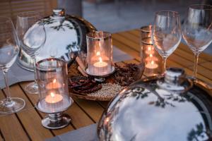 a wooden table with candles and glasses on it at Oceanfront Beach Resort - SHA Extra Plus in Patong Beach