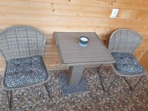 ein Holztisch mit zwei Stühlen und einer Kerze in der Unterkunft La căbănute in Sibiu