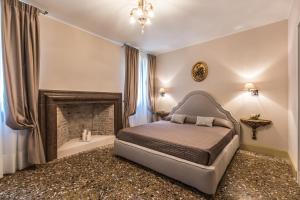 a bedroom with a bed and a fireplace at Palazzina Canal in Venice