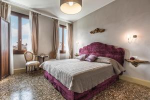 a bedroom with a purple bed with a purple headboard at Palazzina Canal in Venice