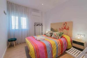 a bedroom with a large bed with a colorful blanket at Precioso apartamento terraza con vistas in Granada