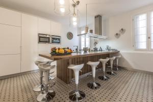 a kitchen with white cabinets and a counter with stools at Palazzina Canal in Venice