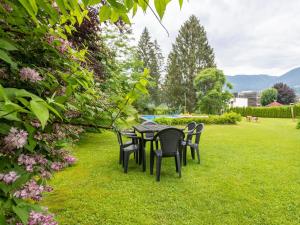 a table and chairs on the grass in a garden at Apartment in Tr polach Carinthia with pool in Tröpolach