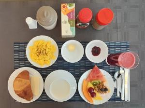 una mesa con platos de comida para el desayuno. en Hodu Hospedaje, en Quito