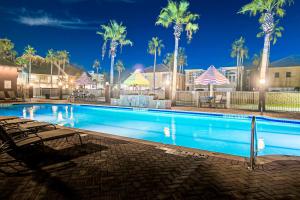 a swimming pool at night with palm trees at Holiday Inn Express Hotel and Suites South Padre Island, an IHG Hotel in South Padre Island