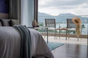 a bedroom with a bed and a table and chairs at Oceanfront Beach Resort - SHA Extra Plus in Patong Beach