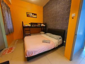 a small bed in a room with a brick wall at Cameron Forest Home - Golden Hills in Cameron Highlands